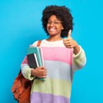 Aptitude Test candidate holding books and smiling
