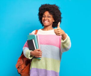 Aptitude Test candidate holding books and smiling