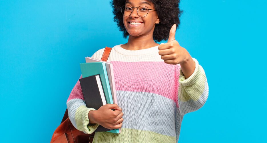 Aptitude Test candidate holding books and smiling